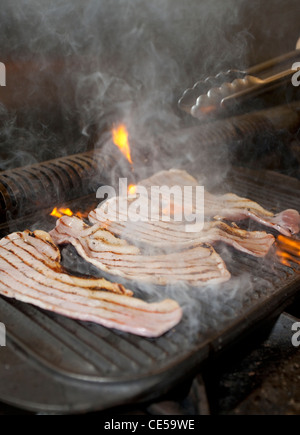 Cuisine anglais bacon éruptions cutanées sur grill ouvert Banque D'Images