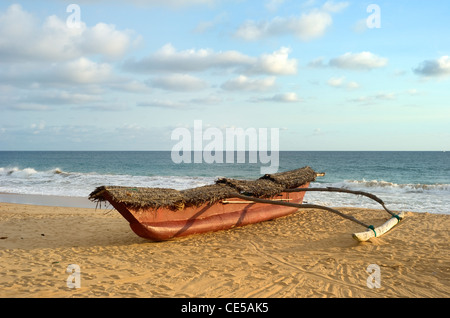 Bateau de pêche traditionnelle du Sri Lanka sur la plage au coucher du soleil de l'océan Banque D'Images