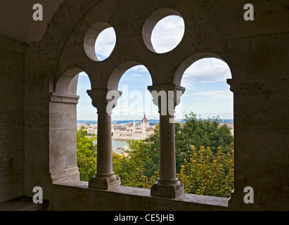 Vue du parlement (Orszaghaz) à travers les remparts de Bastion des Pêcheurs (Halaszbastya), Budapest, Hongrie. Banque D'Images