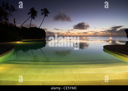 Pacific Resort piscine à débordement, Aitutaki, Îles Cook, Pacifique Sud. Coucher du soleil Banque D'Images