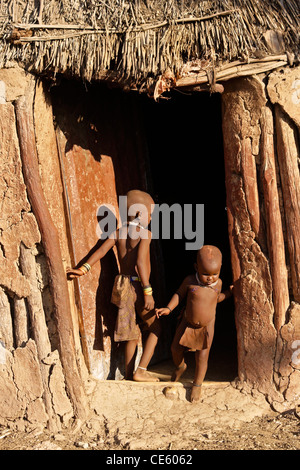 Enfants Himba en face de la Maison dans village près d'Opuwo, Namibie Banque D'Images