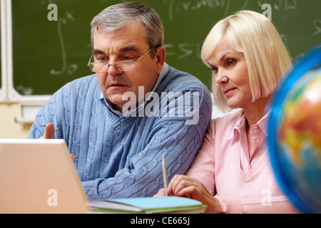 Portrait d'homme mûr et des femmes plus âgées travaillant avec un ordinateur portable au cours de formation Banque D'Images
