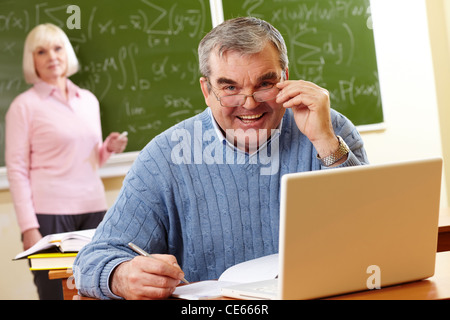 Portrait d'homme âgé looking at camera with senior woman on background Banque D'Images