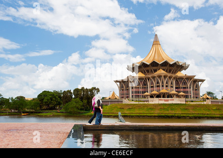 Les femmes malais à marcher le long de la promenade du bord de mer. Kuching, Sarawak, Bornéo, Malaisie Banque D'Images