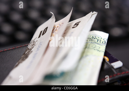 Un £10 et £5 note sur un détenteur de la carte de crédit avec les cartes de crédit à l'intérieur - Le clavier d'un ordinateur à l'arrière-plan Banque D'Images