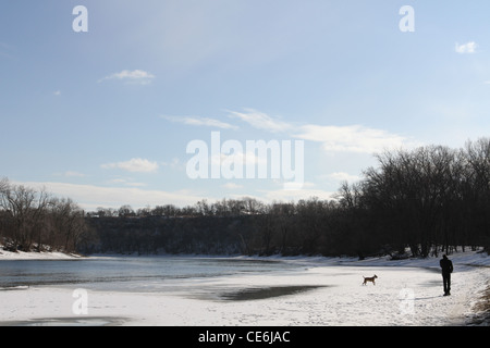 Un homme et un chien autour de l'eau congelée. Banque D'Images