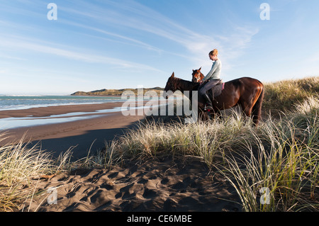 Les femmes avec deux chevaux sur la plage en Nouvelle Zelande Raglan Banque D'Images