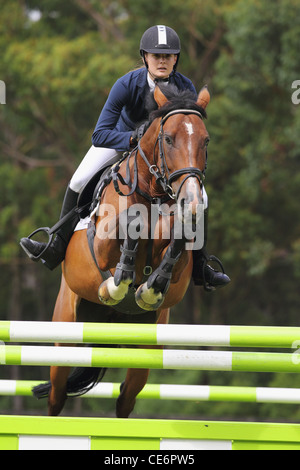 Young Woman Jumping Fence Banque D'Images