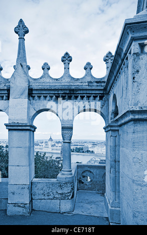 Vue du parlement (Orszaghaz) à travers les remparts de Bastion des Pêcheurs (Halaszbastya), Budapest, Hongrie. Banque D'Images