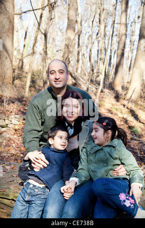 Portrait of a happy smiling family dans la forêt. La mère, le père, son fils et sa fille sont assouplies. Banque D'Images