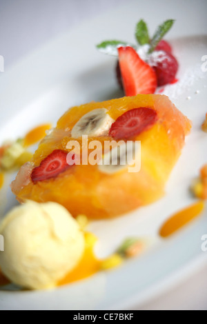 TERRINE DE PAMPLEMOUSSE ROSE ET D'ORANGE AVEC DES FRAISES EN GELÉE DE FRUITS DE LA PASSION AVEC DU MIEL ET DE LA CRÈME GLACÉE AU SAFRAN Banque D'Images