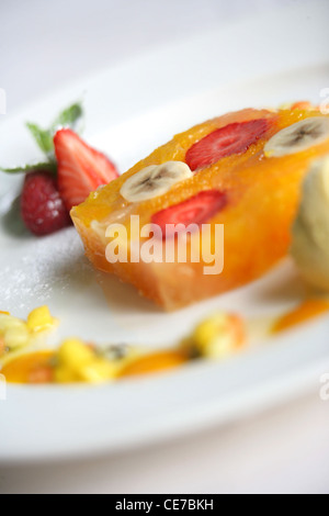 TERRINE DE PAMPLEMOUSSE ROSE ET D'ORANGE AVEC DES FRAISES EN GELÉE DE FRUITS DE LA PASSION AVEC DU MIEL ET DE LA CRÈME GLACÉE AU SAFRAN Banque D'Images