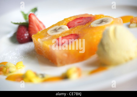 TERRINE DE PAMPLEMOUSSE ROSE ET D'ORANGE AVEC DES FRAISES EN GELÉE DE FRUITS DE LA PASSION AVEC DU MIEL ET DE LA CRÈME GLACÉE AU SAFRAN Banque D'Images