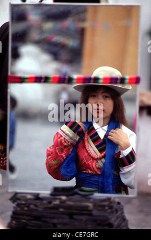 Réflexion dans le miroir d'une jeune chinoise portant un costume de vêtement tibétain traditionnel lors d'une visite du parc culturel des minorités ethniques situé dans la partie sud du parc olympique de Beijing en Chine Banque D'Images
