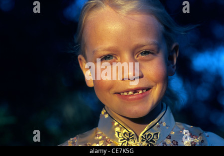 Jeune fille avec une dent manquante en souriant avant le soleil. Banque D'Images