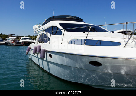 Le petit yacht blanc frais dans un golfe à une jetée Banque D'Images