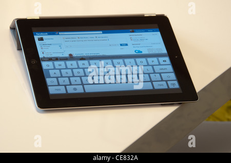 Close up d'un Apple iPad écran montrant le site Facebook sur une élégante table de salon Banque D'Images