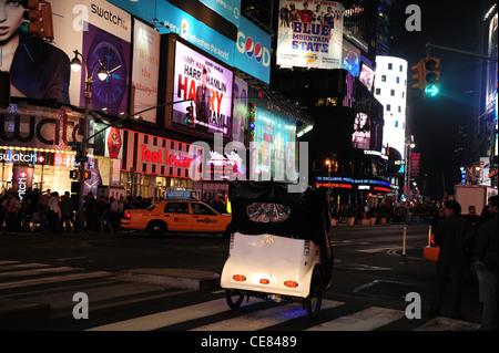 Néon nuit afficher les personnes boutiques rickshaw pedicab taxi jaune, la 7e Avenue, Broadway, West 45th Street, à Times Square, New York Banque D'Images