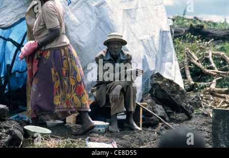 Homme assis par un logement temporaire dans le camp de réfugiés des Nations Unies pour les Hutus rwandais à Goma, République démocratique du Congo, l'Afrique Banque D'Images