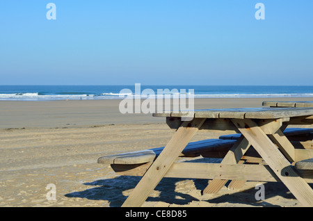 Tables de pique-nique sur la plage avec une vue sur une plage vide Banque D'Images