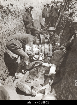 Brancardiers de l'assistance d'un soldat blessé gisant dans une tranchée sur la Somme, la France pendant la Première Guerre mondiale. Banque D'Images