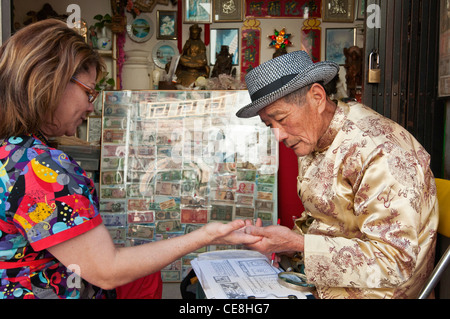 Les gens obtenant leurs paumes pour lire leur fortune par Leo au calembour Il Fortune Lectures à Los Angeles, Chinatown. Banque D'Images