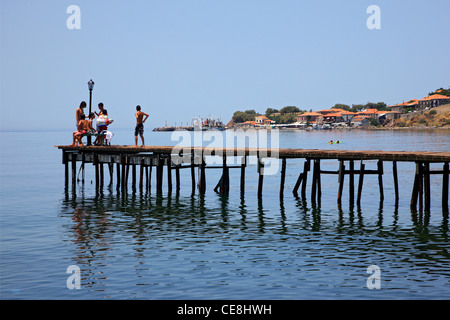 Une bande d'enfants s'amusant sur une chaude journée d'été sur la jetée de la ville de Molyvos, île de Lesvos, Grèce Banque D'Images