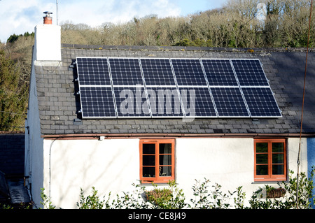 Des panneaux solaires installés sur le toit d'un vieux cottage Banque D'Images