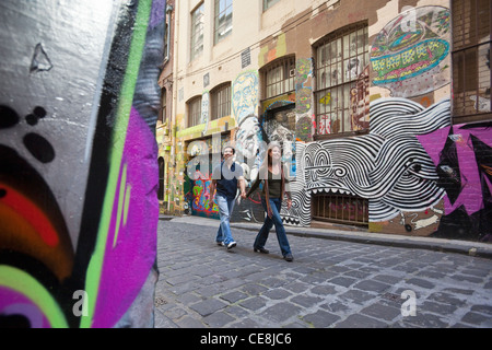 Jeune couple à la recherche de l'art de rue en ruelle. Hosier Lane, Melbourne, Victoria, Australie Banque D'Images