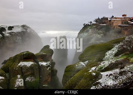 Grèce, Météores. Ambiance hivernale avec du brouillard et de la neige. Sur la partie supérieure droite le grand Meteoron monastère. Banque D'Images
