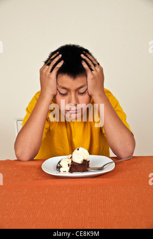 Volontaire les 10-11 ans woman sitting at table ne veut pas manger. multi diversité raciale diversité raciale cultura multiculturelle Banque D'Images