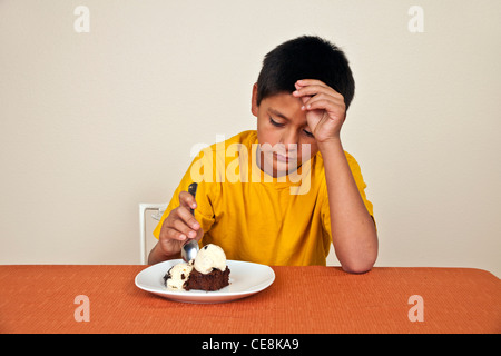 Volontaire les 10-11 ans woman sitting at table ne veut pas manger.MR © Myrleen Pearson Banque D'Images