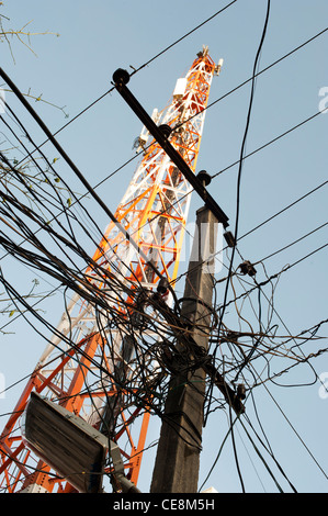 Pylône de l'électricité et les câbles à l'avant d'une tour de télécommunication dans une rue indienne. L'Andhra Pradesh, Inde Banque D'Images