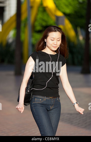 Jeune femme à l'écoute de l'iPod, Cockle Bay, Sydney, Australie Banque D'Images