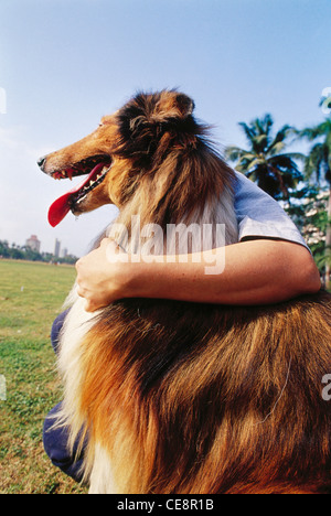 80408 SOA : man embracing dog Bombay Mumbai maharashtra Inde Banque D'Images