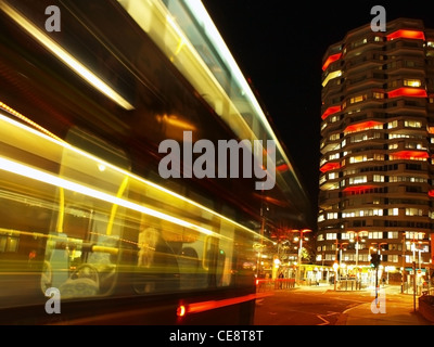 Un bus passe, laissant dans son sillage des sentiers de lumière. Dans l'arrière-plan est l'allumé en officeblock de Croydon n°1 Banque D'Images