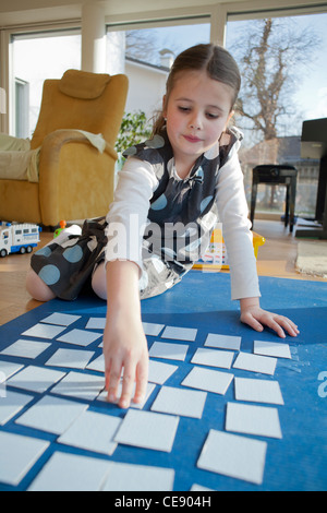 Les jeunes filles à jouer jeu de cartes mémoire sur le sol. Banque D'Images
