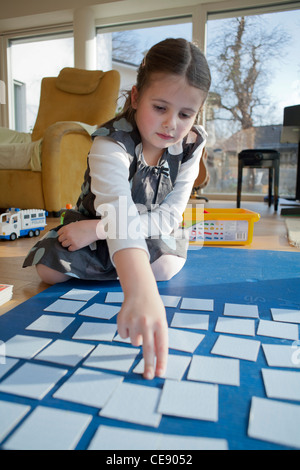 Les jeunes filles à jouer jeu de cartes mémoire sur le sol. Banque D'Images