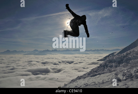 Snowboarder saute une montagne contre le soleil tomber en fin de journée sur la montagne Nordkette Innsbruck, Autriche ci-dessus Banque D'Images