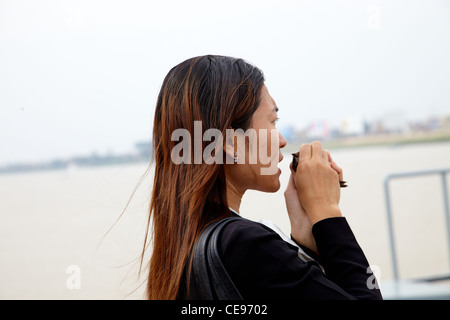 Woman whispering doucement d'un petit oiseau. Elle prie pour la bonne fortune. Banque D'Images