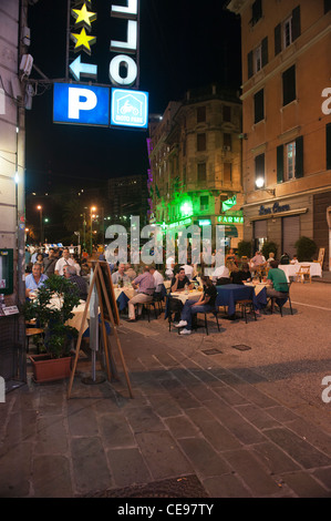 Les gens boire et manger dans la rue des bars et restaurants de nuit. Vieille ville de Gênes (Genova), Italien Italie Banque D'Images