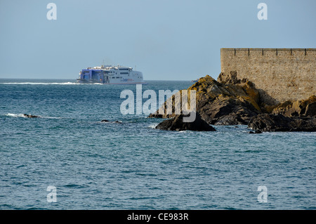 Un ferry quitte St Malo et loin du Fort National (Bretagne, France). Banque D'Images