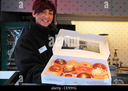 Smiley girl selling donuts sur la rue Banque D'Images