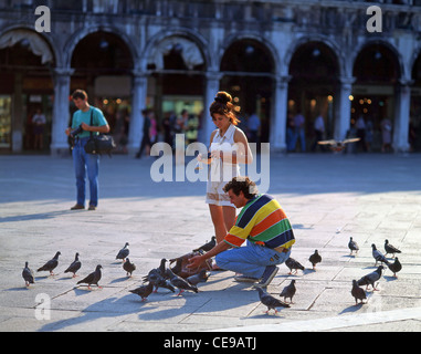 Couple de pigeons d'alimentation dans la place Saint-Marc, Venise, Venise, Vénétie, province de l'Italie Banque D'Images