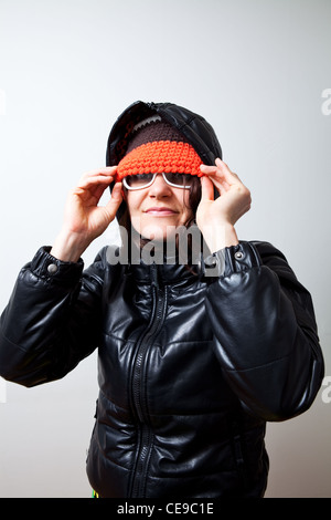 Jeune femme à la mode cool avec un capot noir et coloré hat. Studio shot. Banque D'Images