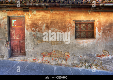 Old vintage maison abandonnée avec petite fenêtre et porte en bois dans la ville de La Morra, au nord de l'Italie. Banque D'Images