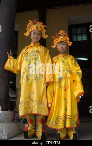 Les enfants vêtus de costumes traditionnels de la cour royale afin de se faire photographier à la citadelle de Hue, Vietnam. Banque D'Images