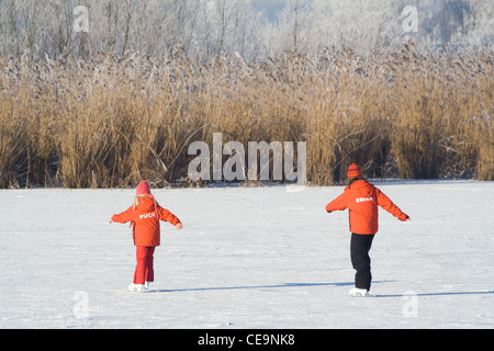 Deux enfants du patin à glace sur un lac gelé en Hollande Banque D'Images