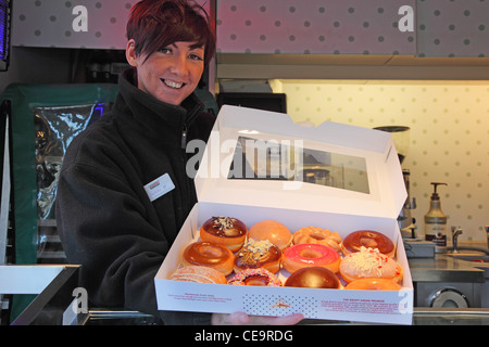 Smiley girl selling donuts sur la rue Banque D'Images