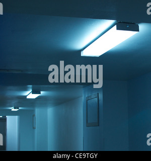 Plafonniers fluorescents dans un passage souterrain entre les bâtiments. Bleu monochrome. Format carré. Banque D'Images